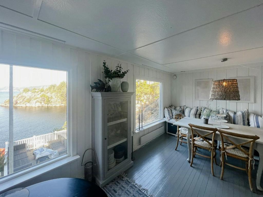 una sala da pranzo con tavolo e vista sull'acqua di Charming Sea Cabin On Fluer By Kragerø a Valle
