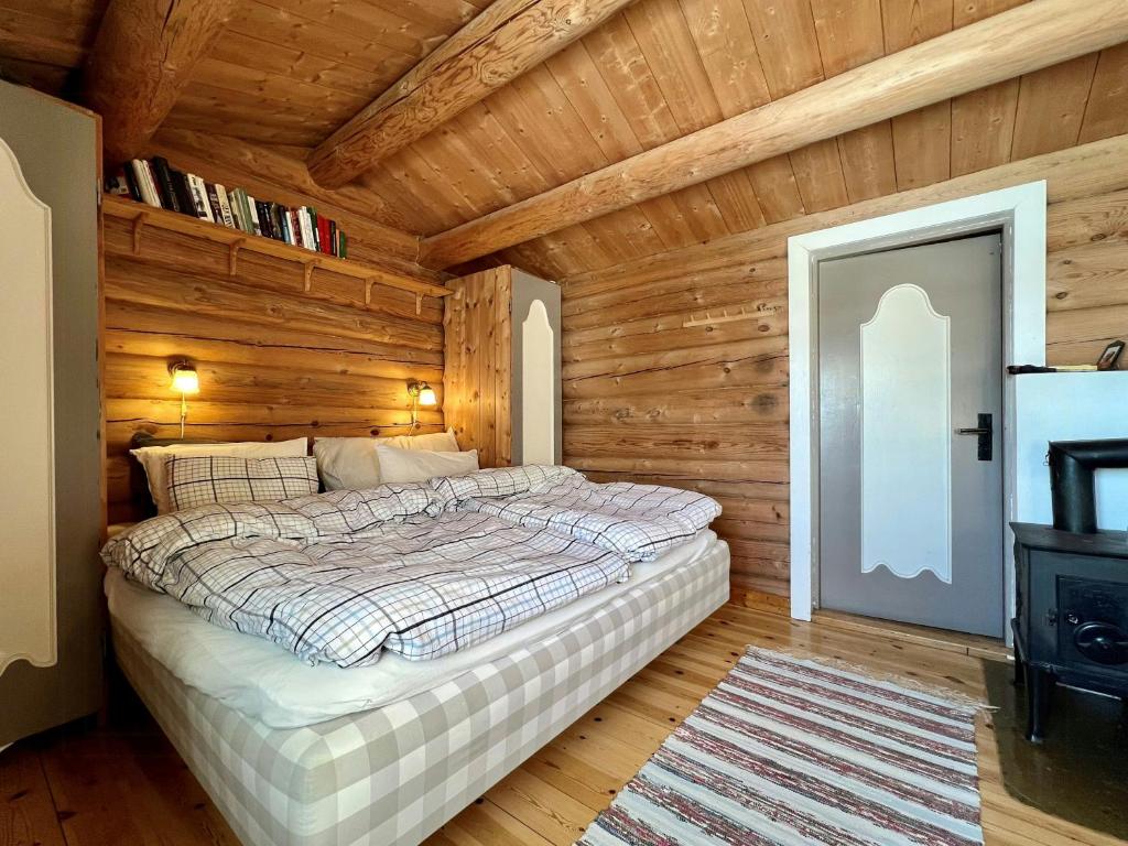 VenabygdにあるCharming Cabin Near Rondane National Parkの木製の壁の部屋にあるベッドのある寝室