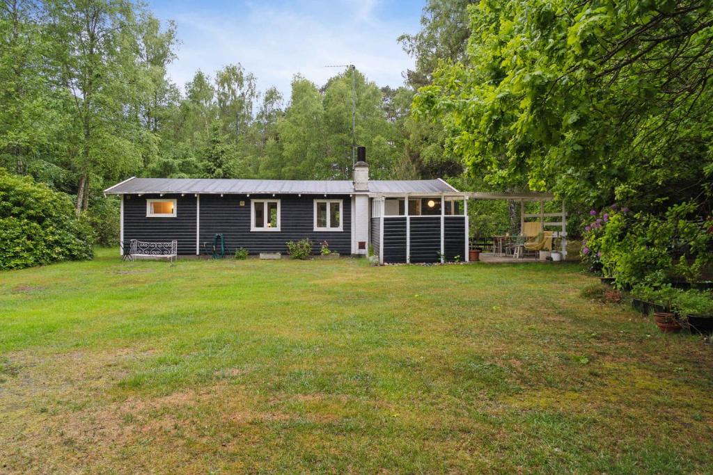 ein kleines Haus mit einem Garten davor in der Unterkunft Cozy Holiday Home Near The Beach And Nature in Frederiksværk