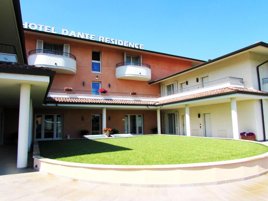 a building with a green lawn in front of it at Hotel Dante Residence in Mantova