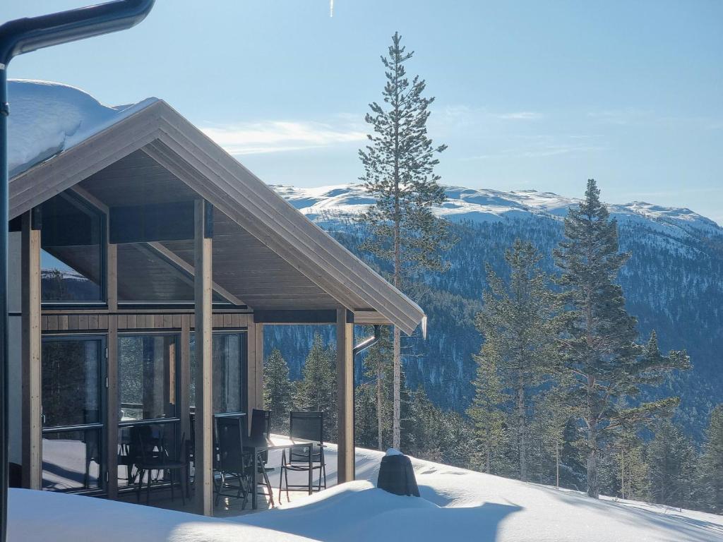 a house in the snow with mountains in the background at Modern Cabin With Panoramic View On Bringsfjellet in Lalm