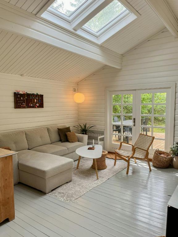 a living room with a couch and a table at Fine Details In Forest Setting In Ebeltoft in Ebeltoft