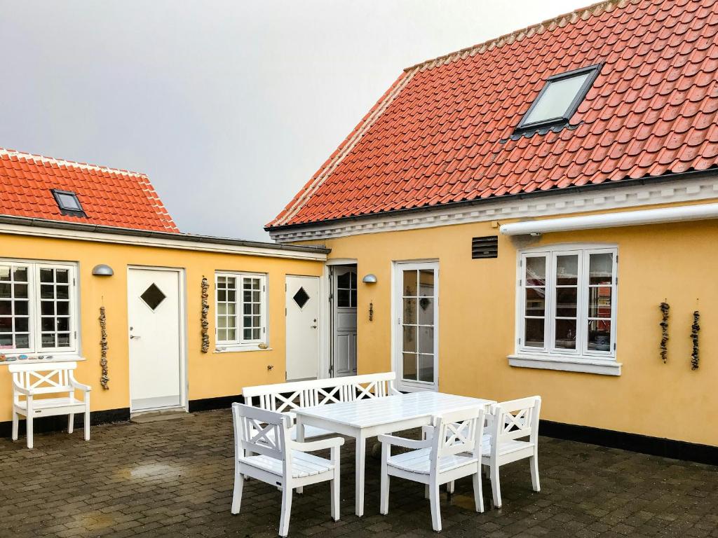 a table and chairs in front of a house at Live In Classic Skagen House In Skagen's Heart in Skagen