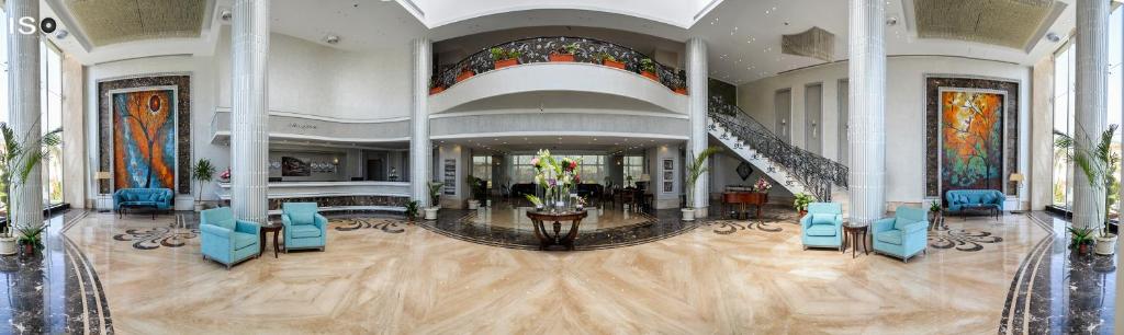 a lobby with blue chairs and a staircase in a building at Tolip El Narges in Cairo