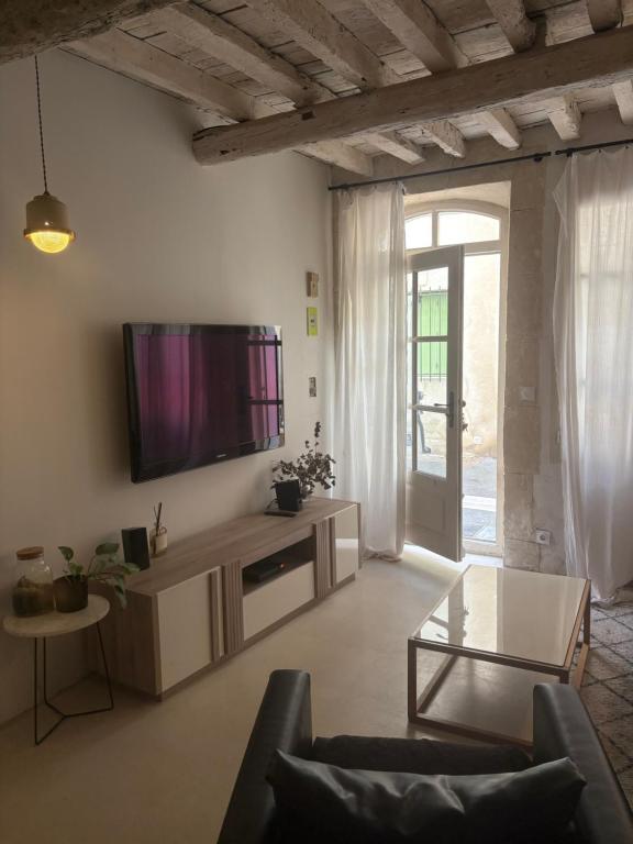 アルルにあるMaison quartier la Roquetteの壁に薄型テレビが取り付けられたリビングルーム