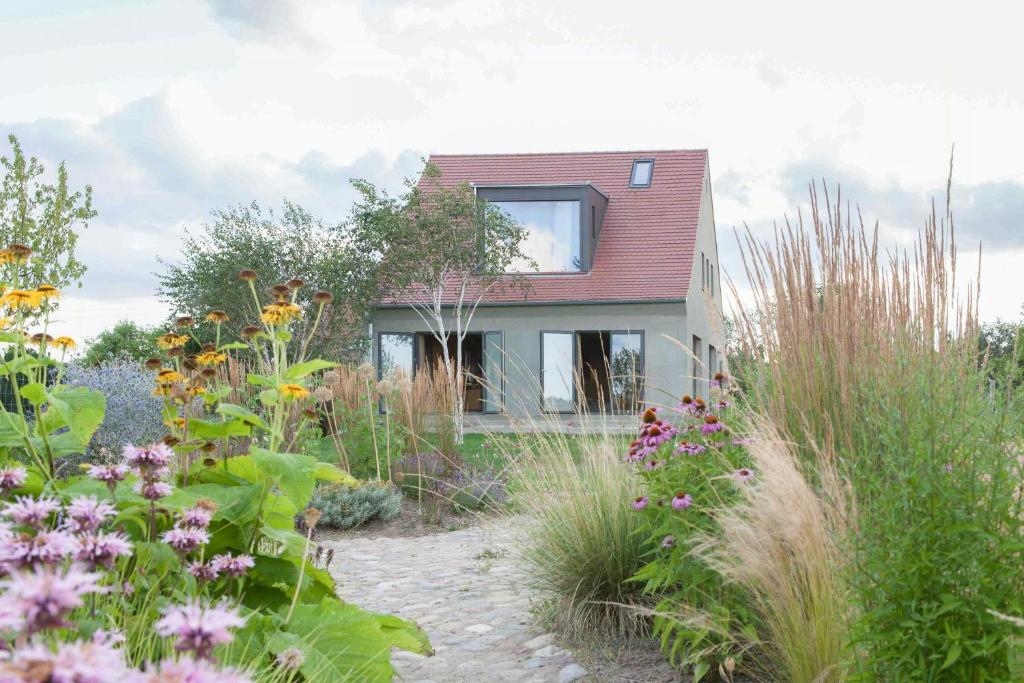 a garden with flowers in front of a house at Architectural Gem On The Cornfield in Lindenhagen