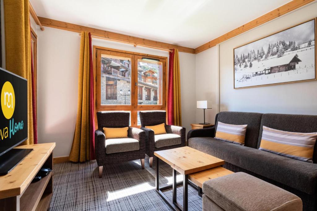 un salon avec un canapé, des chaises et une télévision dans l'établissement Résidence Les Arcs 1950 Le Village - maeva Home - Appartement 3 Pièces 6 Personnes - Prestige MAE-6704, à Bourg-Saint-Maurice