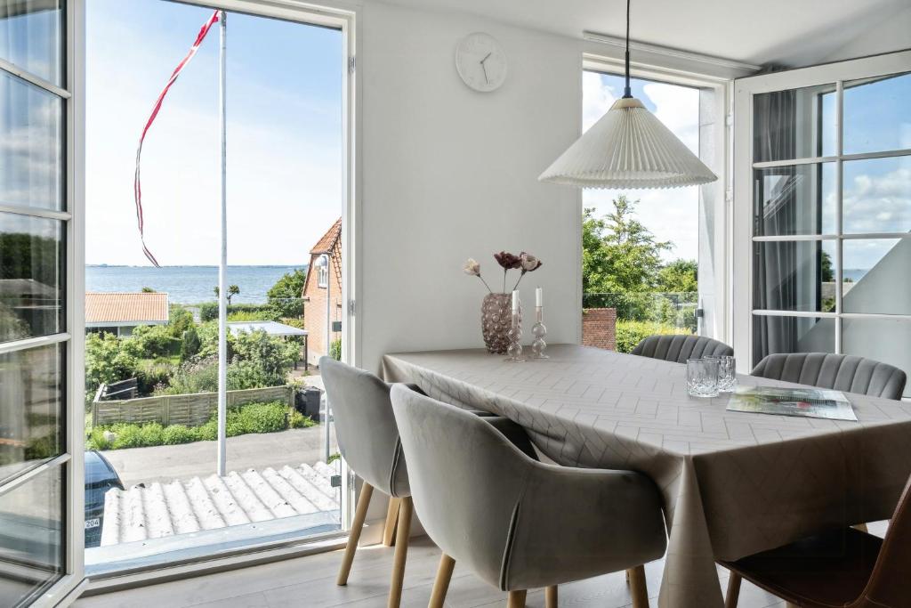 a dining room with a table and chairs with a view of the ocean at Enjoy Møn From Historic House in Stege