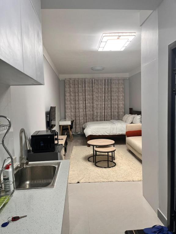 a kitchen with a sink and a living room at The City escape Sabaki green estate - 15 minutes to JKIA and SGR in Marimbeti