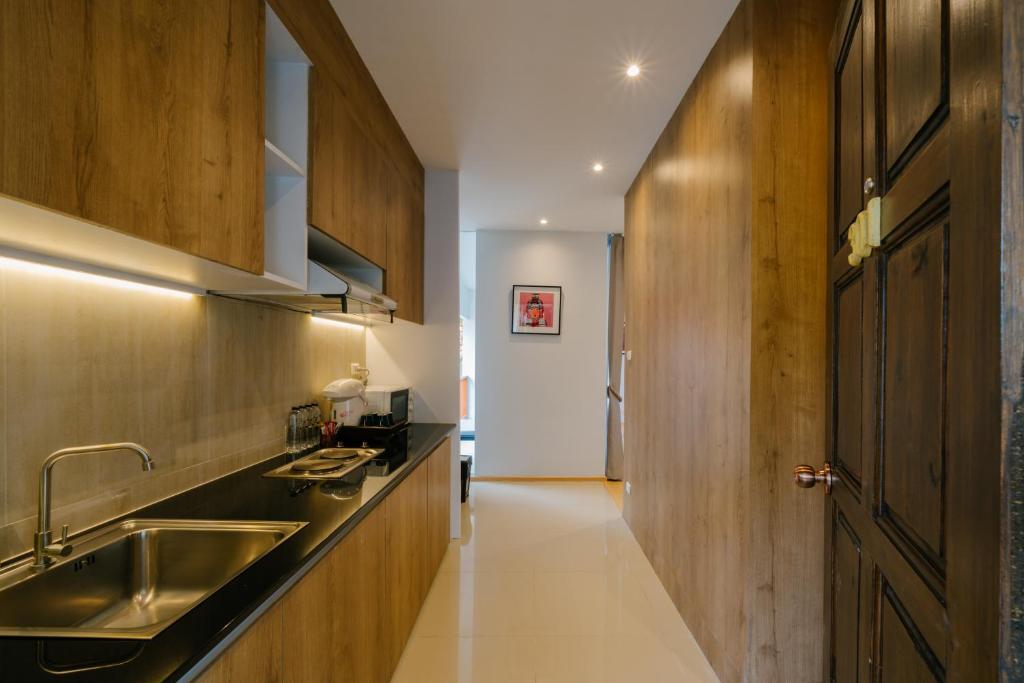 A narrow wood-paneled kitchen corridor with a sink and cooking counter.