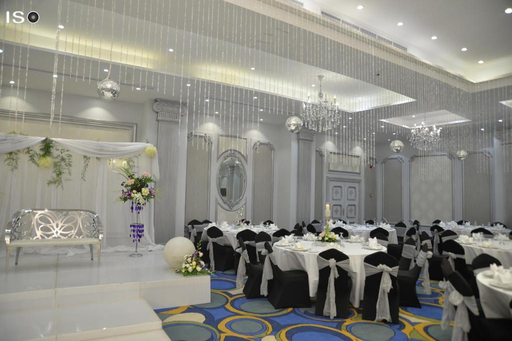 a banquet hall with white tables and black chairs at Tolip El Narges in Cairo