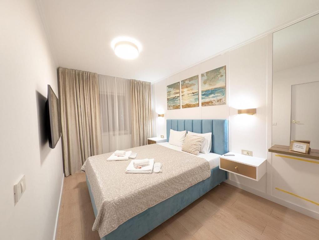 a bedroom with a bed with two towels on it at Imedio Coral Apartment Aviatiei in Bucharest