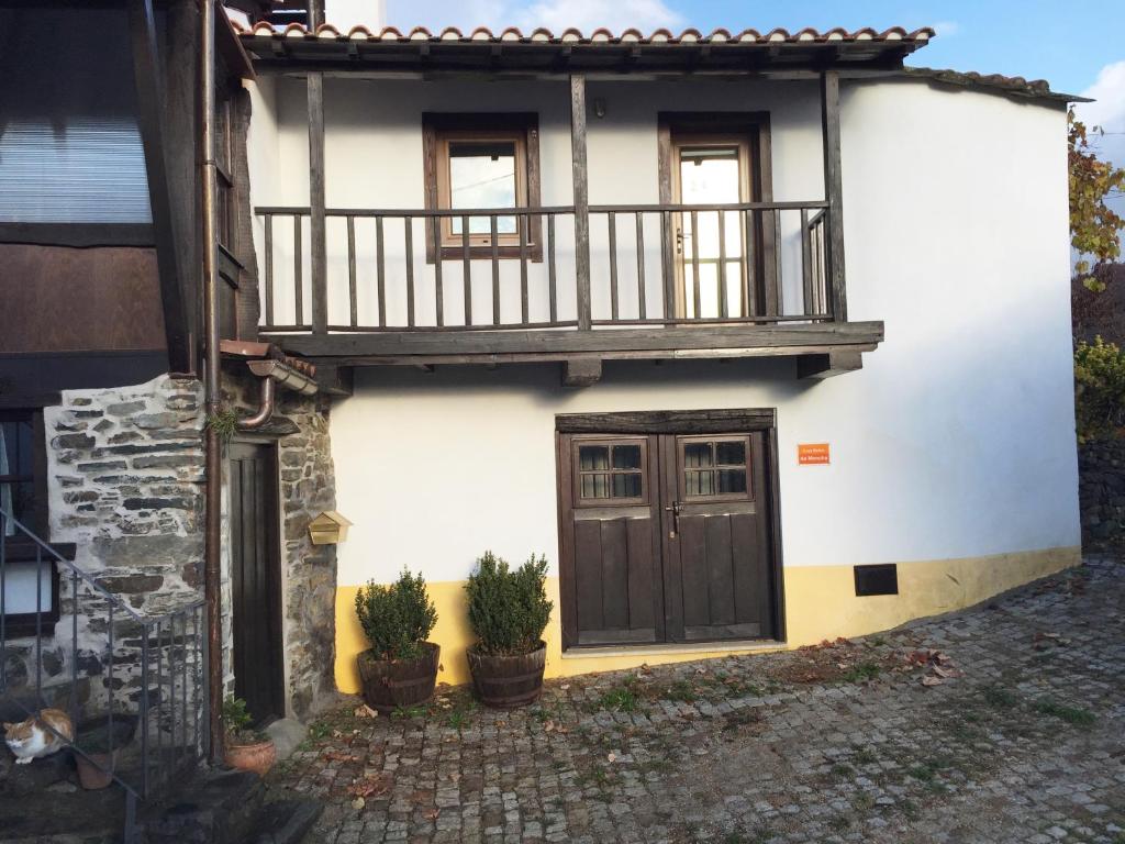 a white house with a balcony and a door at Casa da Mencha in Vinhais