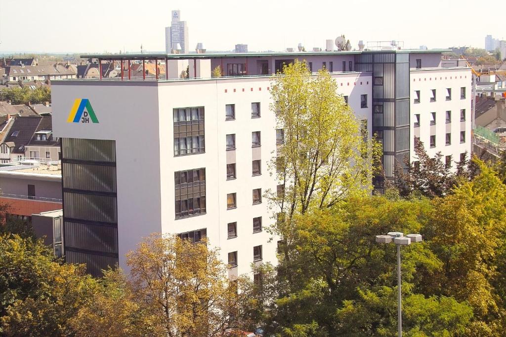 a white building with a logo on the side of it at Jugendherberge Köln-Deutz in Cologne
