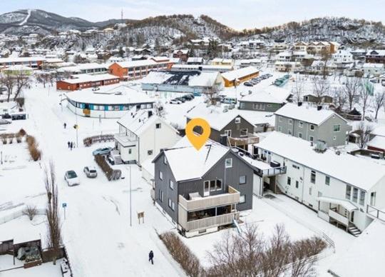 a town covered in snow with a yellow circle on its roof at Praktisk 3 roms leilighet in Bodø