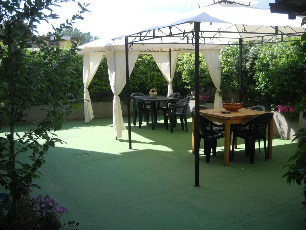 a table and chairs under a white umbrella at Giorno&Notte Colleferro in Colleferro