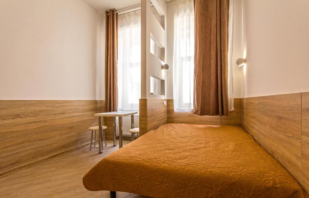 リヴィウにあるKrehivska 7-1のベッドルーム1室(ベッド1台、テーブル、窓付)