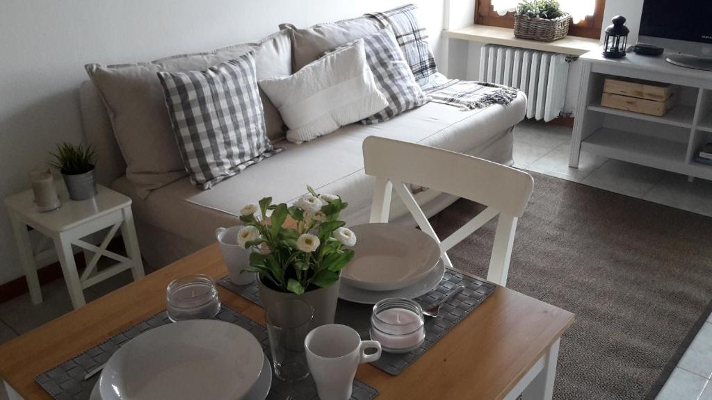 sala de estar con sofá y mesa con flores en Aurora Appartamenti, en Negrar