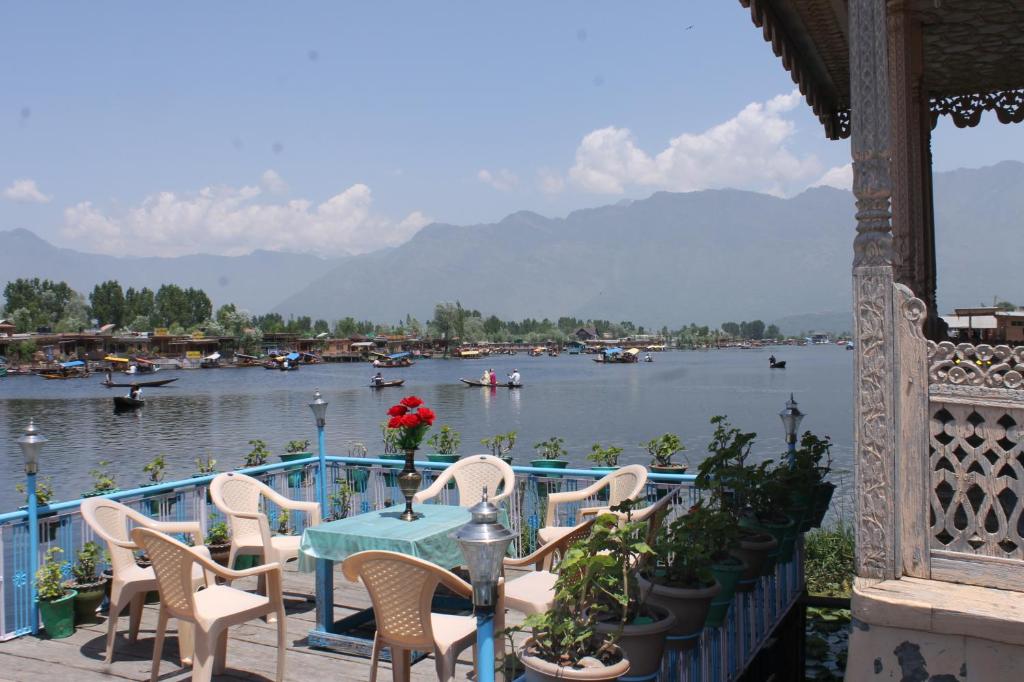 a table and chairs with a view of a body of water at Young Beauty Star Houseboat in Srinagar