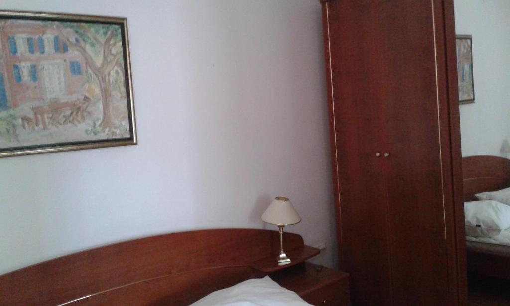 um quarto com uma cama, um candeeiro e um espelho em Apartment Delfina em Ist