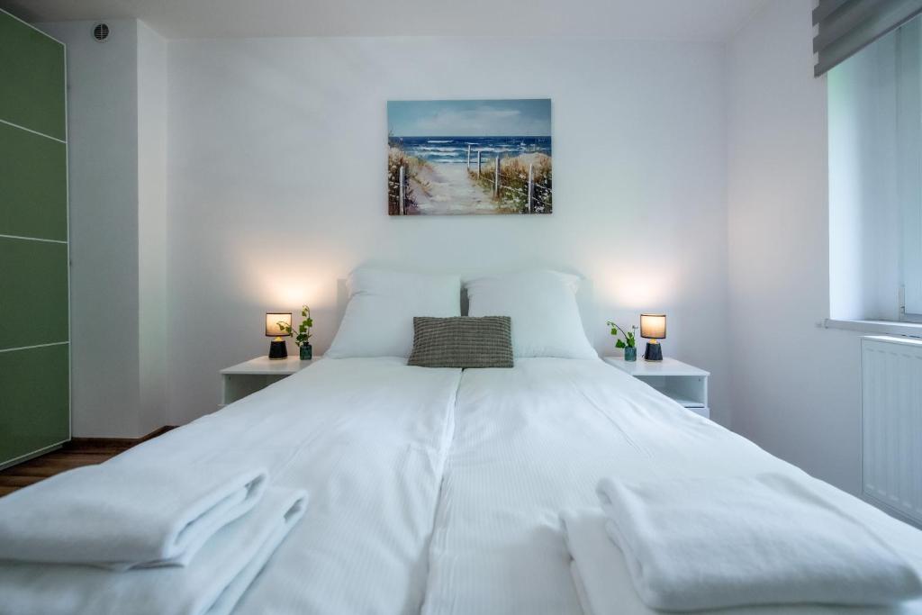 a bedroom with a large white bed with two lamps at Apartament Lipowa 26 in Gliwice