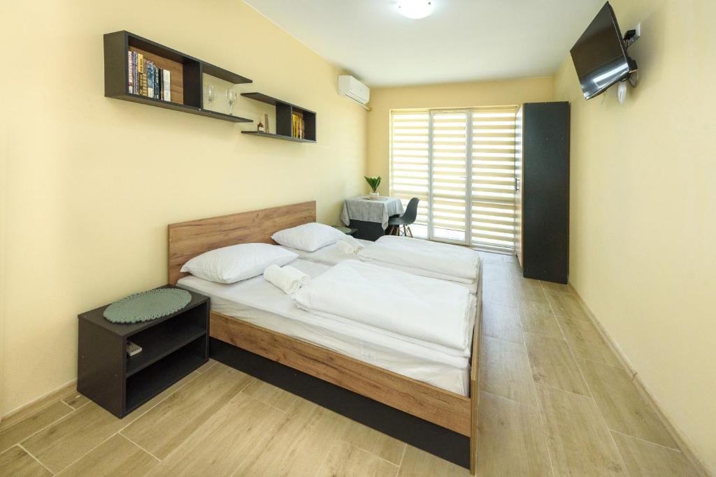 a bedroom with a large bed with a television on the wall at Maracuya Apartment in Veliko Tŭrnovo