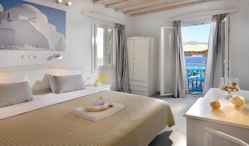 a hotel room with white walls and a white bed at Hotel Nazos in Mikonos