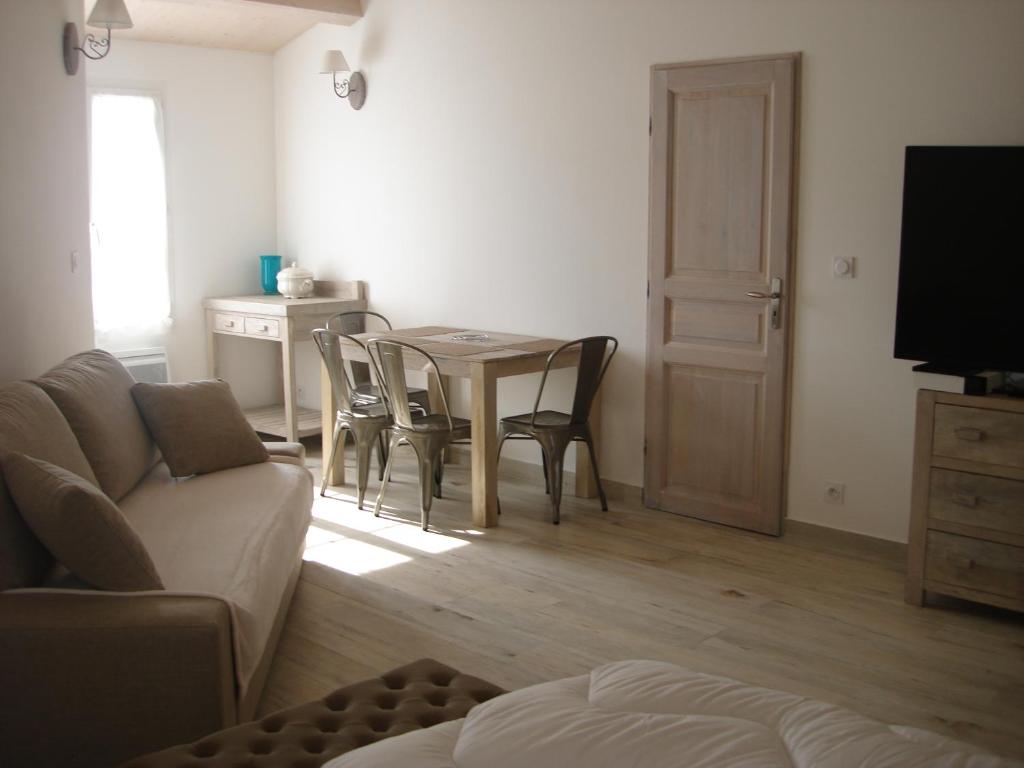 a living room with a table and chairs and a couch at Locations Ile de Ré in Sainte-Marie-de-Ré