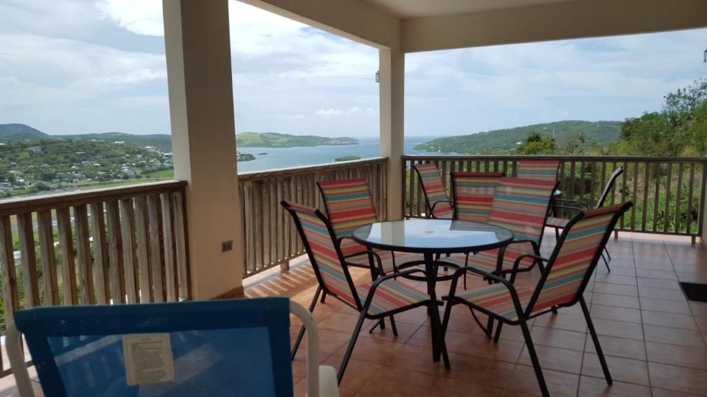 a balcony with a table and chairs and a view of the water at Vista Bella Apartments in Culebra