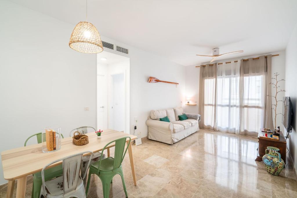 een woonkamer met een tafel, stoelen en een bank bij BLUE BEACH HOUSE, Retamar, Cabo de Gata in Almería