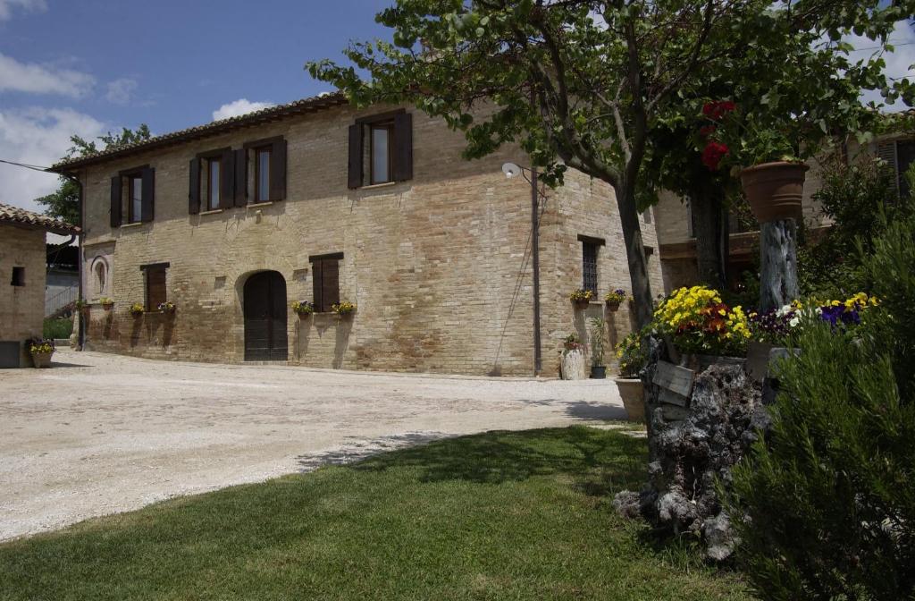 a large brick building with a tree in front of it at Agriturismo Il Borghetto in Montefalco
