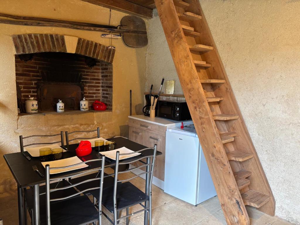 L ancien fournil - Sejour authentique & douillet - Proche de Sarlat في Calviac: مطبخ مع طاولة ومطبخ مع سلم