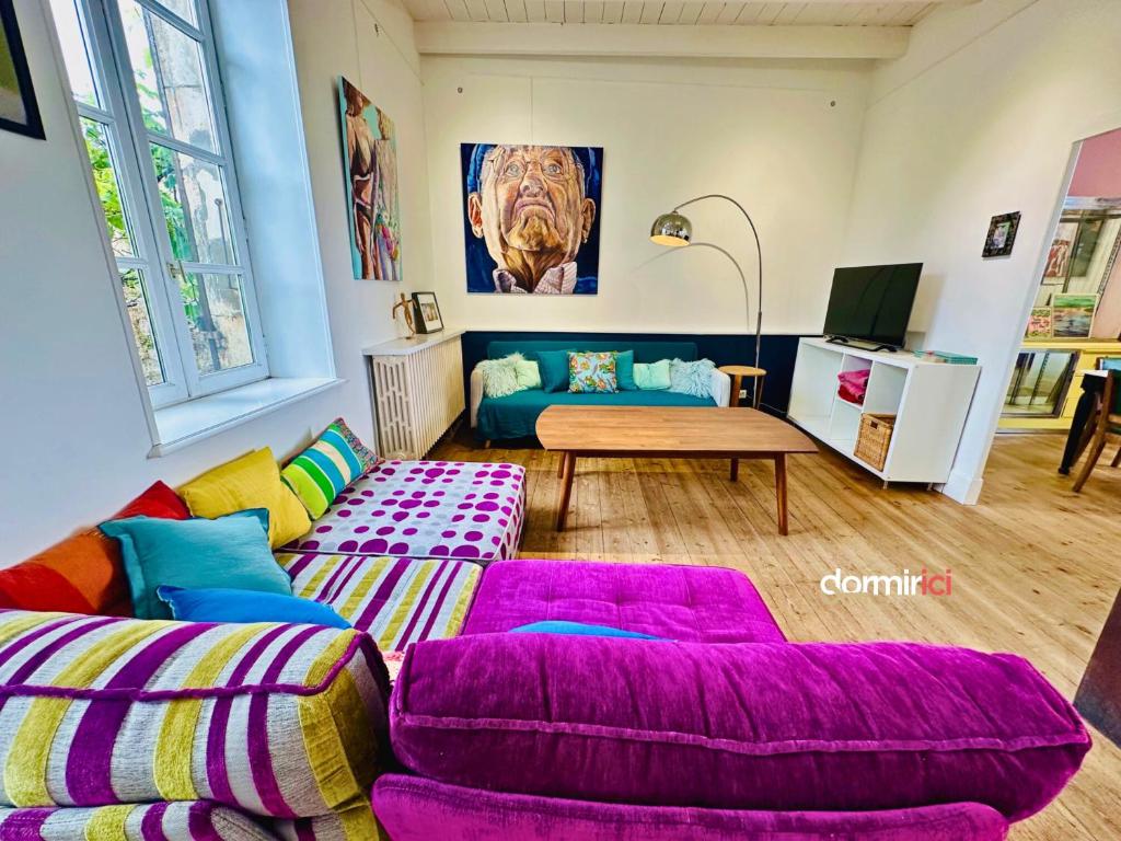 un salon avec un canapé et une table dans l'établissement Maison GALERIE - Port de Mornac & Art de vivre, à Mornac-sur-Seudre