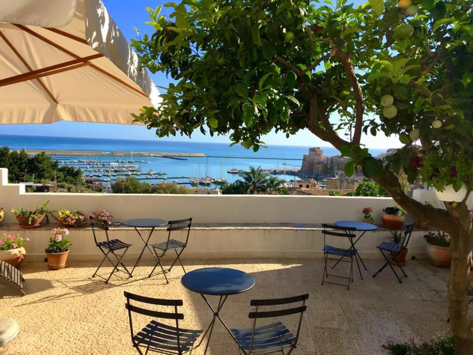 a patio with tables and chairs and a view of the ocean at Santina in Castellammare del Golfo