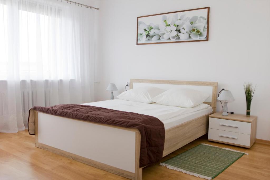 una camera bianca con un grande letto e una finestra di Hotel Mława a Mława