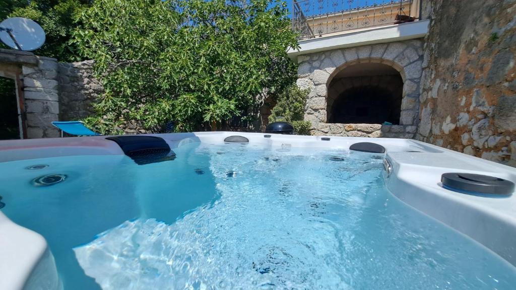 a jacuzzi tub in a stone building with water at Villa Bartola in Grižane