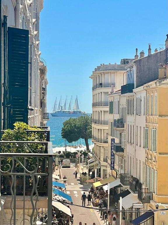 une rue de ville avec des bâtiments et un port avec des navires dans l'établissement Le Pinson Mignon Cannes Carre d Or, à Cannes