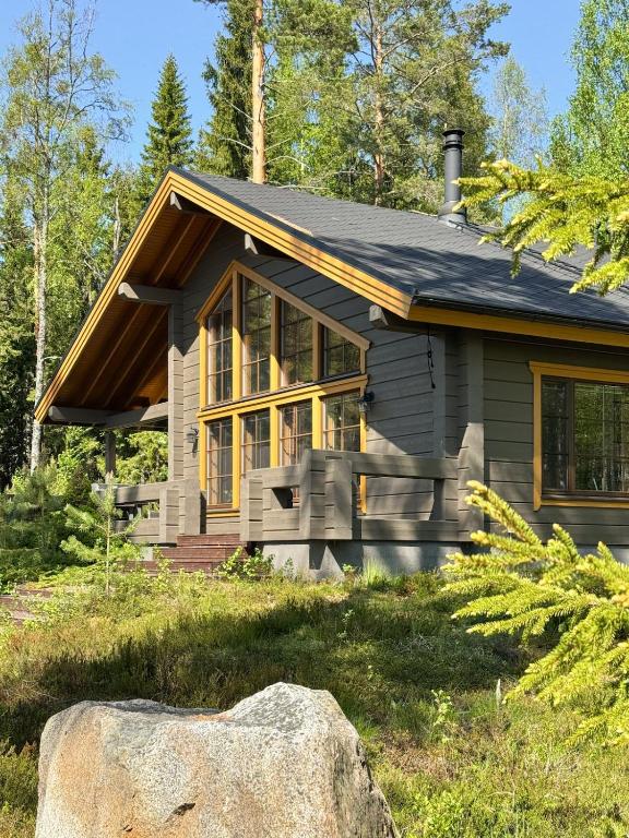 una pequeña casa con una roca delante de ella en AureenHelmi, en Aurekoski