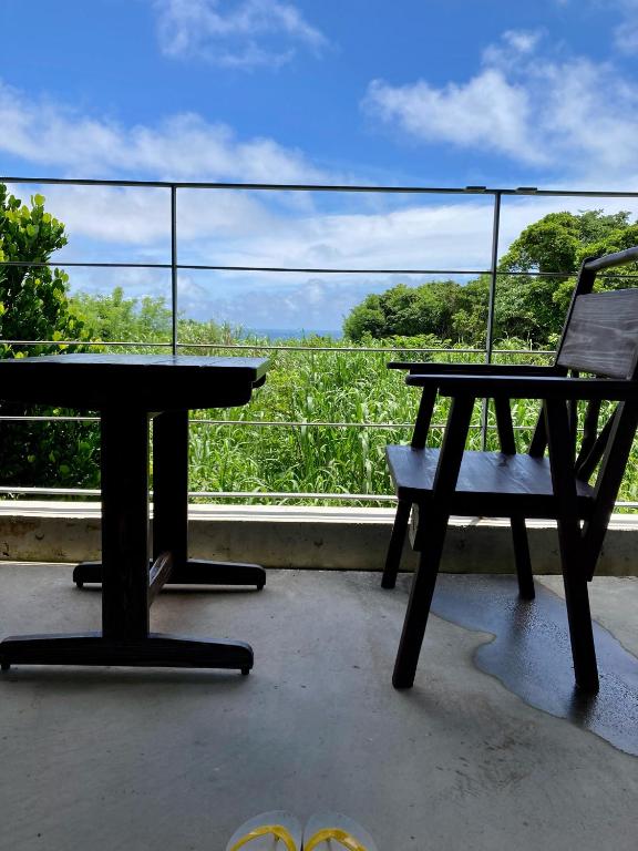a picnic table and a bench sitting on a balcony at Asahinoyado Shidakaji in Nanjo