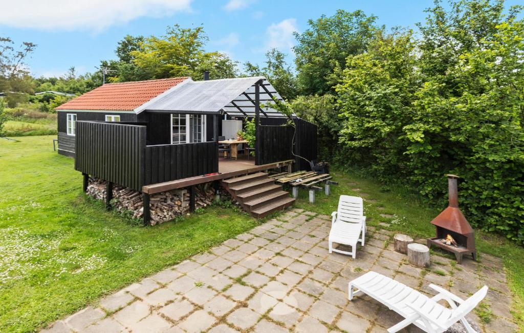 a black cabin with a deck and a table and chairs at 2 Bedroom Gorgeous Home In Glesborg in Glesborg