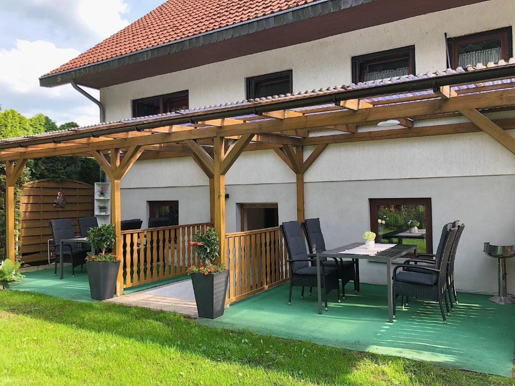 a patio with a table and chairs under a wooden pergola at Naturblick am Petersdorfer See in Petersdorf