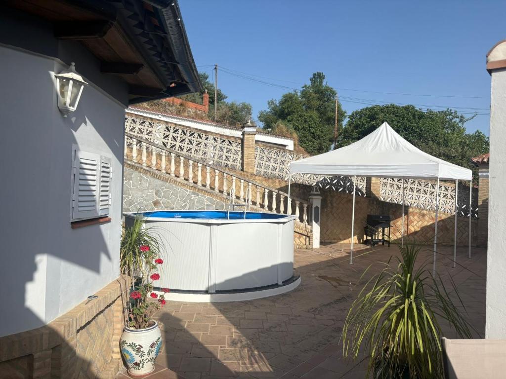 una vasca idromassaggio sul lato di una casa con una tenda di Apartamentos turísticos ilusiones a Cazalla de la Sierra