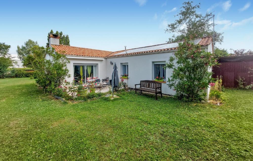 una casa blanca con un banco en un patio en Charmante Maison En Vendée, en Commequiers