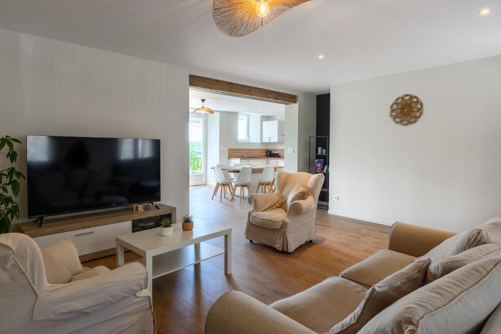 un salon avec une télévision à écran plat et un canapé dans l'établissement Gîte dans un village Aveyronnais, à Lunac