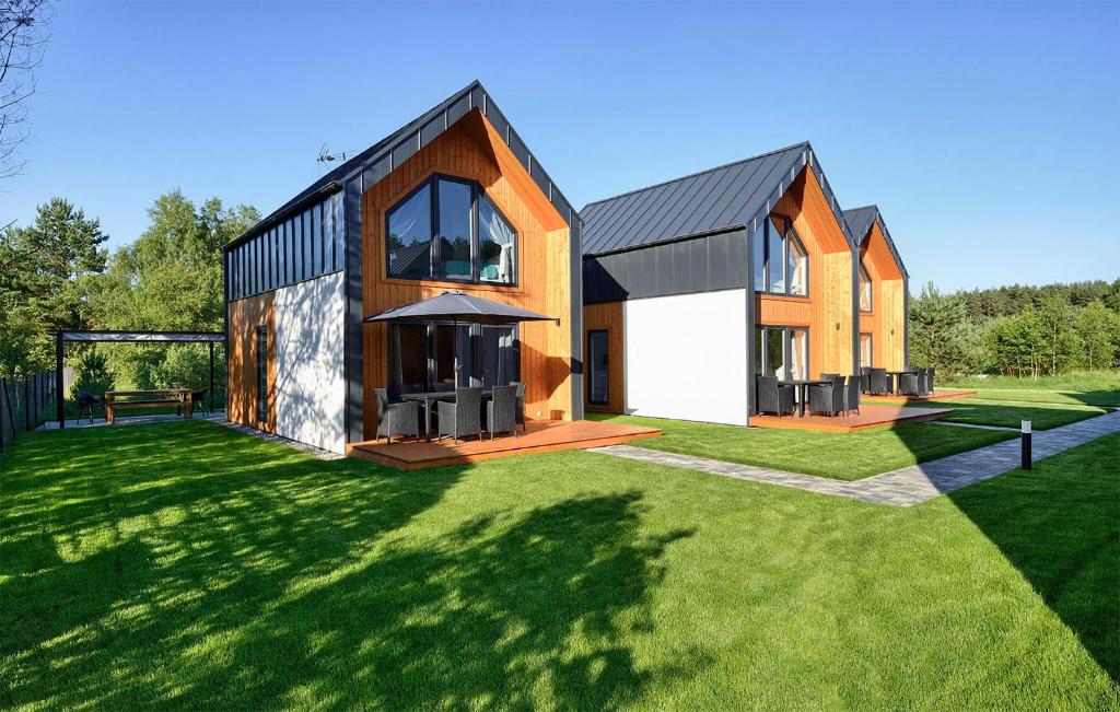 a house with a large yard with green grass at Nice Home In Bialogora With Wifi in Białogóra