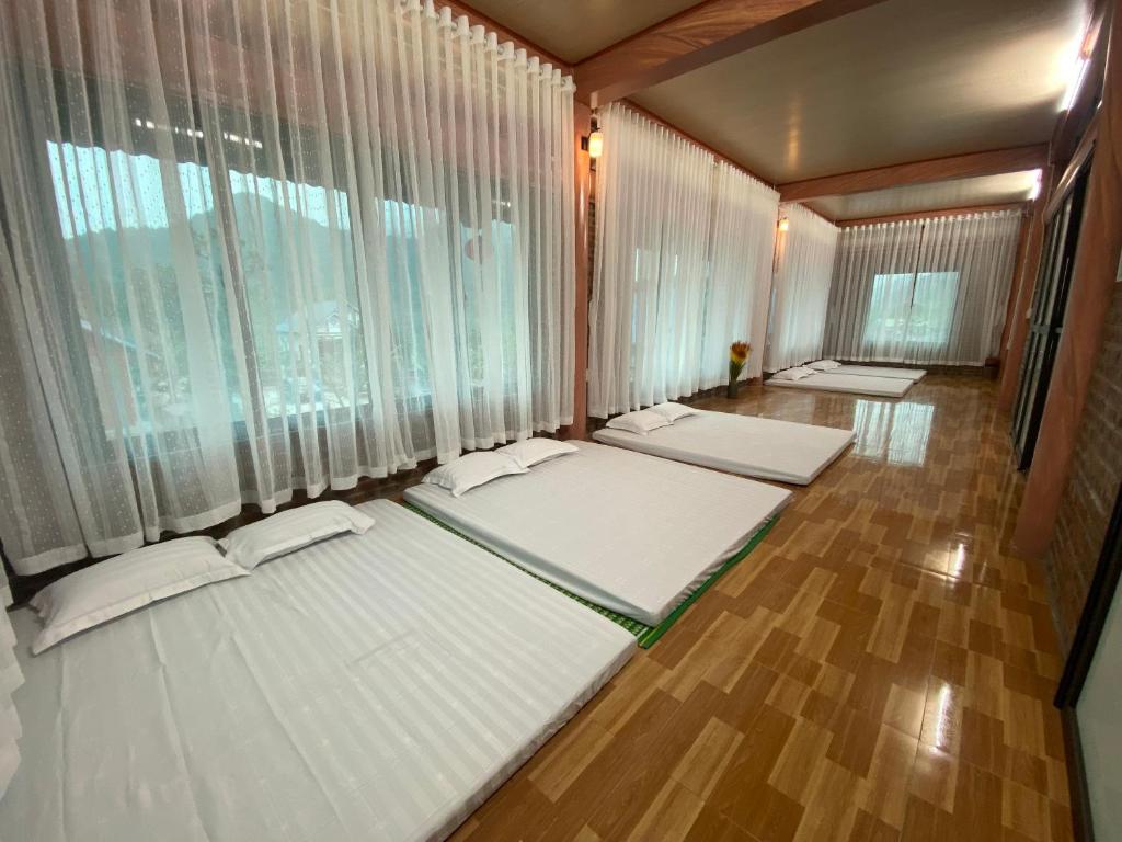a room with three beds in a room with windows at Thung Din Homestay in Phủ Nho Quan