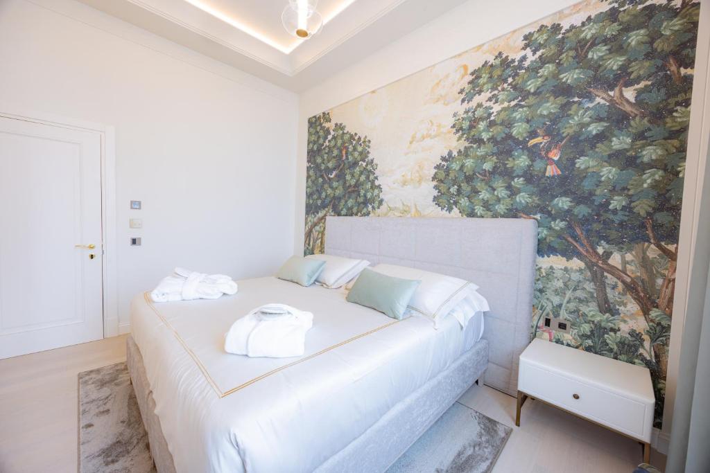 a bedroom with a white bed with a painting on the wall at Hotel Belvedere in Forte dei Marmi