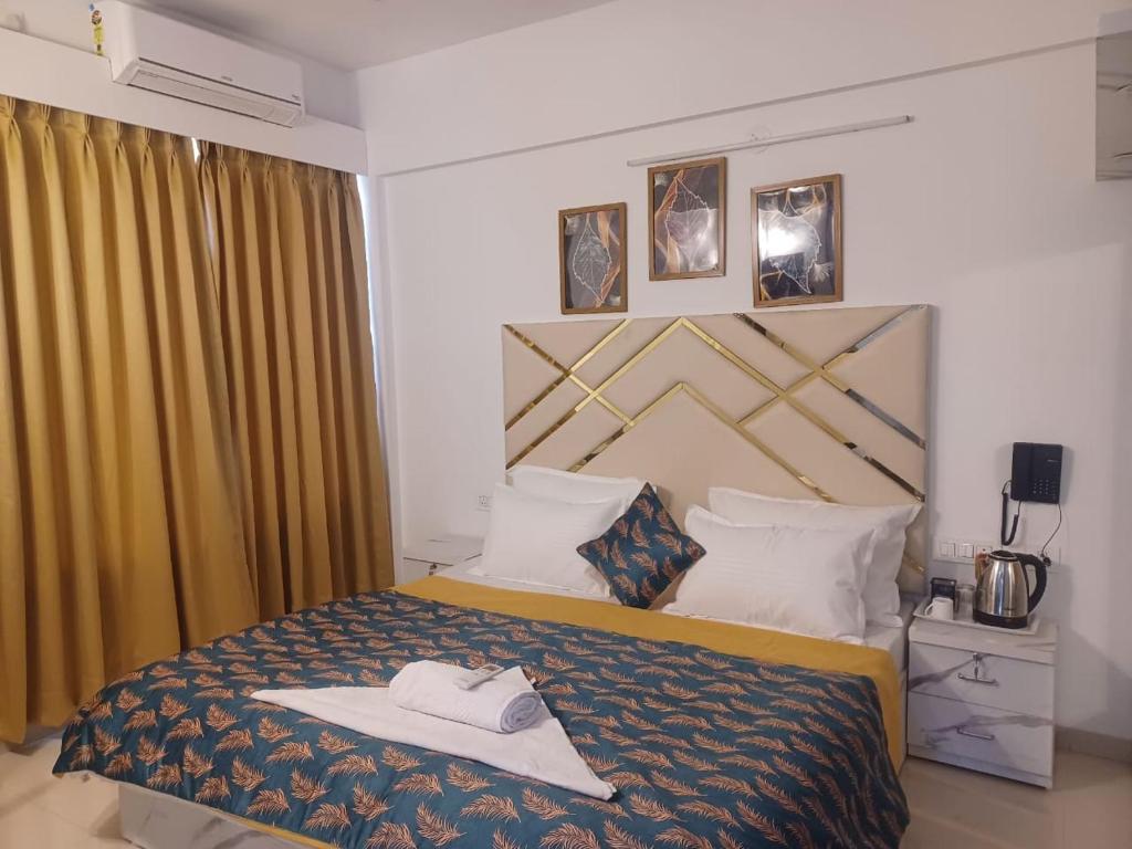 ein Schlafzimmer mit einem großen Bett und einem gelben Vorhang in der Unterkunft EXPAT STYLED 2 BHK IN BANER BALEWADI , Pune in Pune