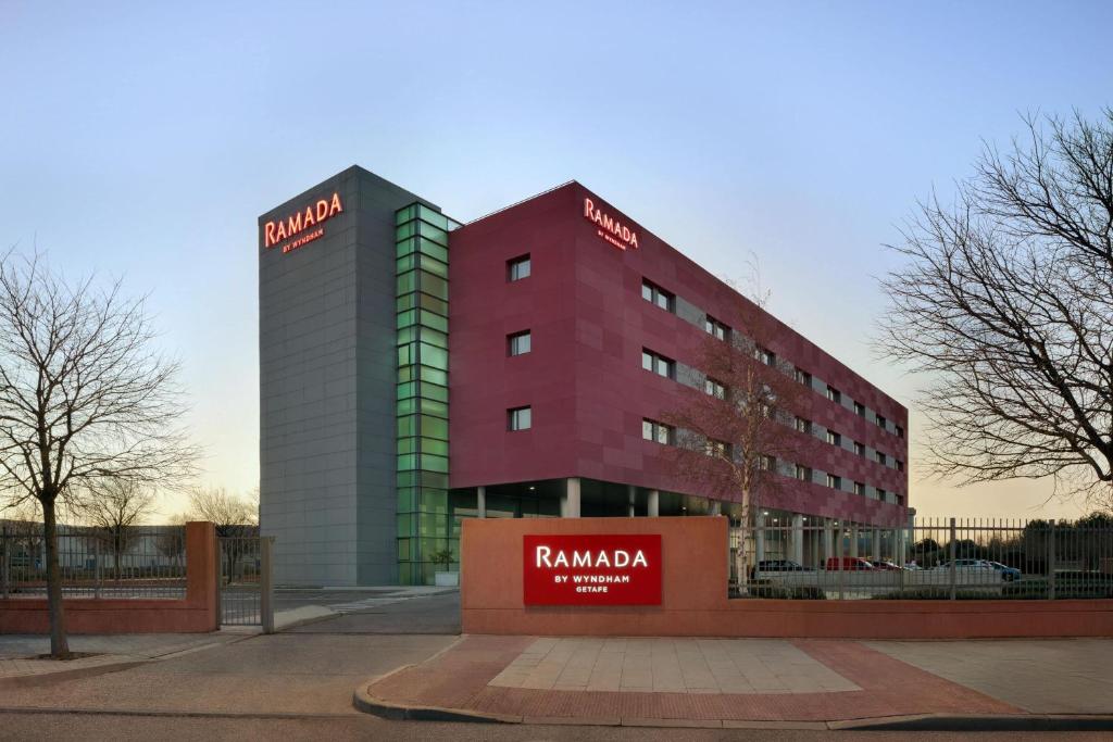a tall red building with a sign on it at Ramada by Wyndham Madrid Getafe in Getafe