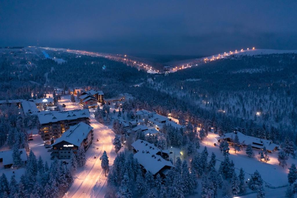 a town in the snow at night with lights at Kuukkeli Saariselkä Inn in Saariselka